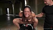 Tied brunette trainee Lyla Storm standing tied with heavy plates in hands and vibrator between legs then in pile driver position anal fucked by gimp