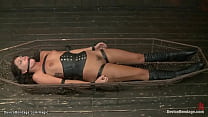 Brunette lesbian slave Cassandra Nix in pink dress is bent over gets ass cattle prodded then laid and strapped in cage hairy pussy wired and pumped