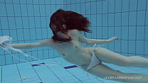 Floating babe in the warm pool getting naked