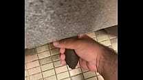 Giving a handjob to uncut BBC under a stall in a public bathroom