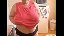 Lonely BBW Grandma moves around in the kitchen with naked boobs.